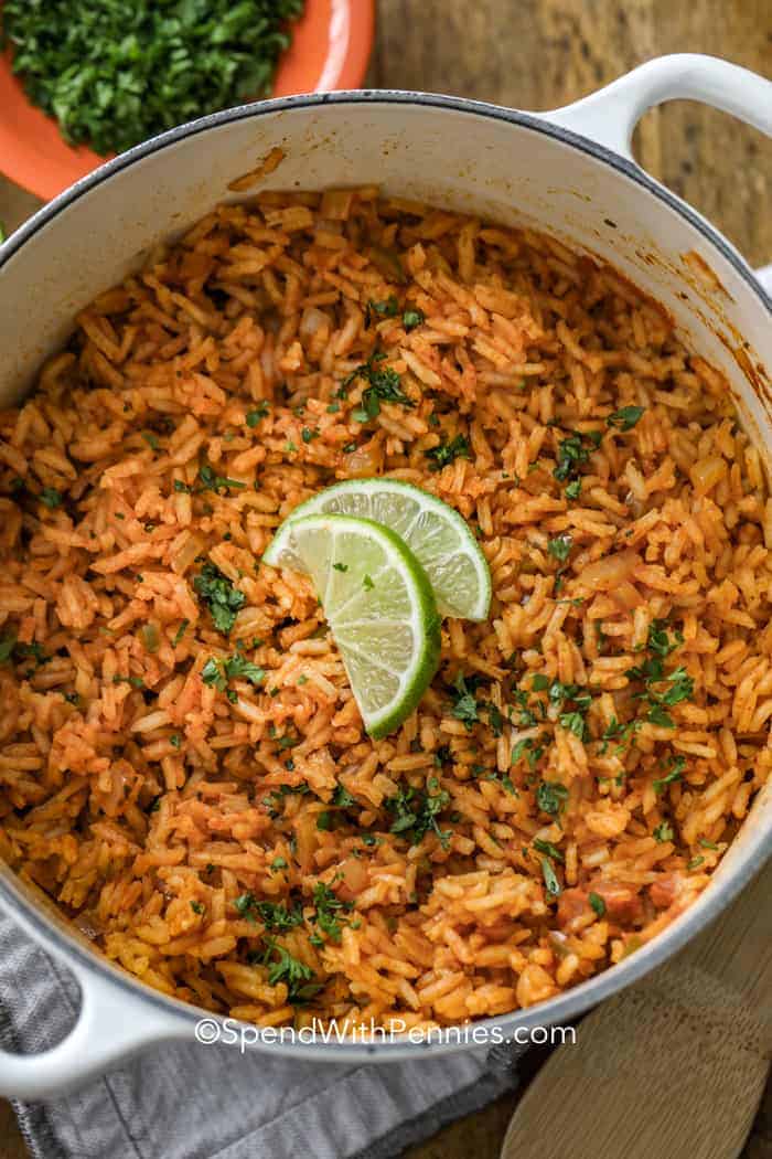 Rice cooked in a pot and topped with cilantro and lime