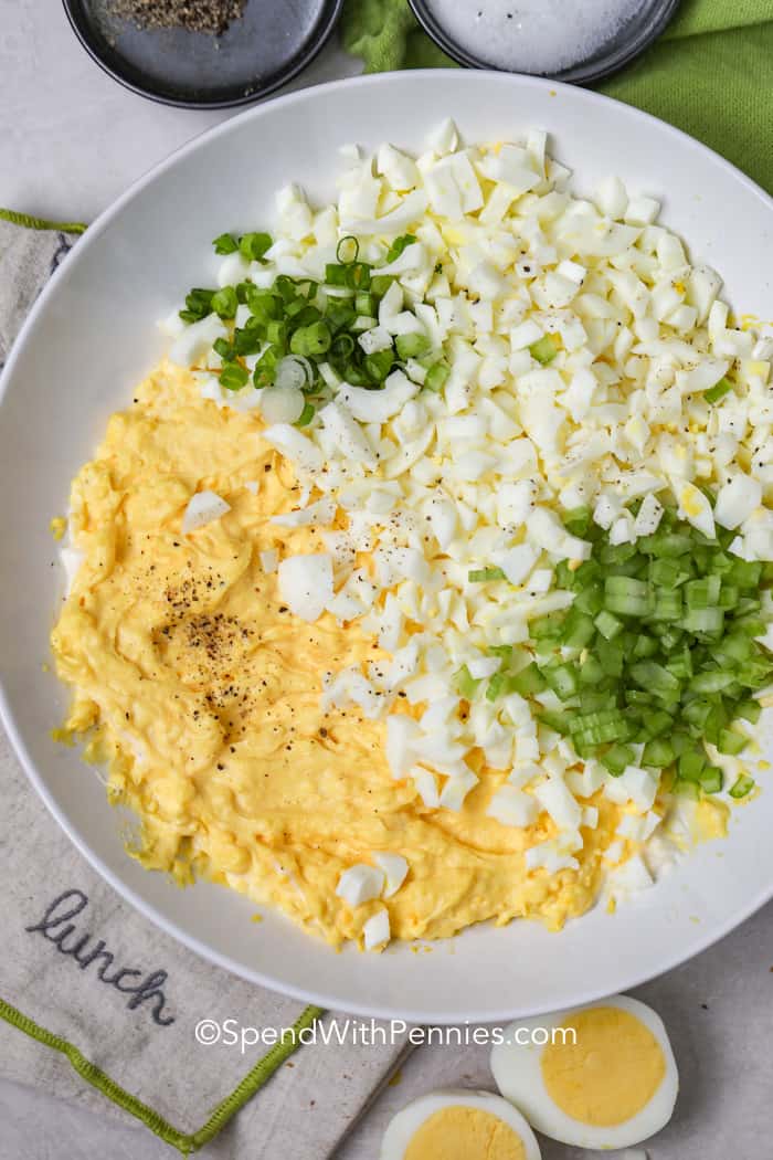We love serving this easy egg salad recipe in egg salad sandwiches in the summer. Make egg salad for a picnic, a potluck, or for a quick and easy lunch! It's the best egg salad recipe ever! #eggsalad #eggsaladsandwich #homemadeeggsalad #spendwithpennies Overhead shot of egg salad ingredients before being mixed together