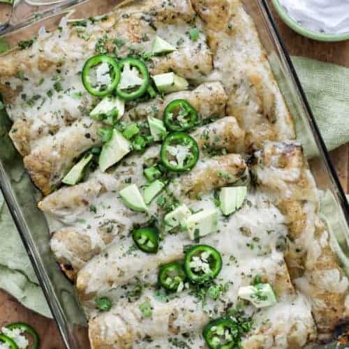 Green Chilli Chicken Enchiladas with sour cream and avocado shown from overhead