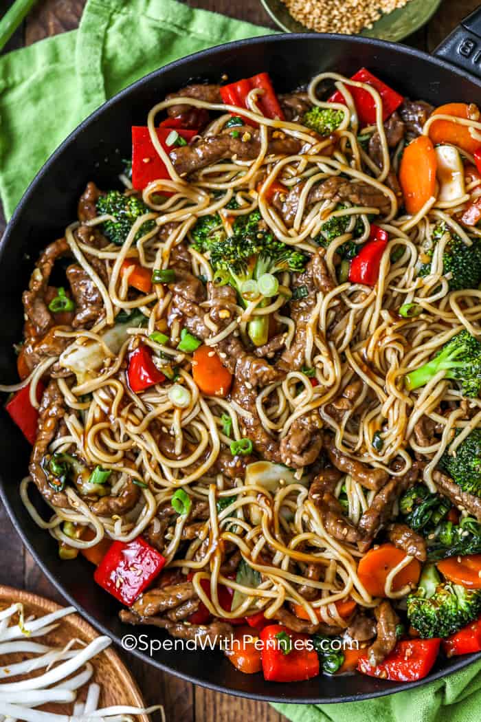 Serve this beef stir fry recipe that tastes just like it was made in a Chinese restaurant. Tender and juicy beef are cooked with as assortment of vegetables in this easy to make recipe. It is finished off with a sweet, salty, ginger sauce. The last step is to serve this all over a bed of noodles or rice. #beefstirfry #beefstirfryrecipe #stirfrywithbeef #spendwithpennies Overhead shot of Beef Stir Fry in a black pan