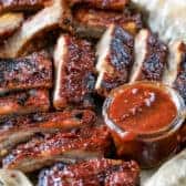 Crock Pot Ribs on a baking sheet with dipping sauce