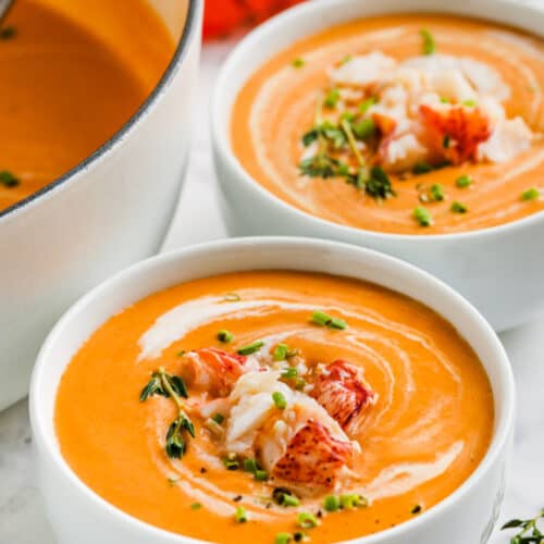 bowls of lobster bisque garnished with lobster