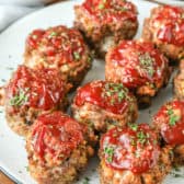 Meatloaf Muffins on a plate with vegetables in the background