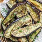 Roasted eggplant on parchment paper with a fork