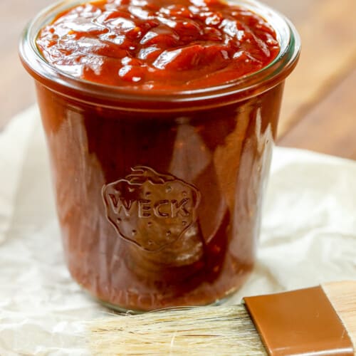 a jar of homemade bbq sauce with a brush