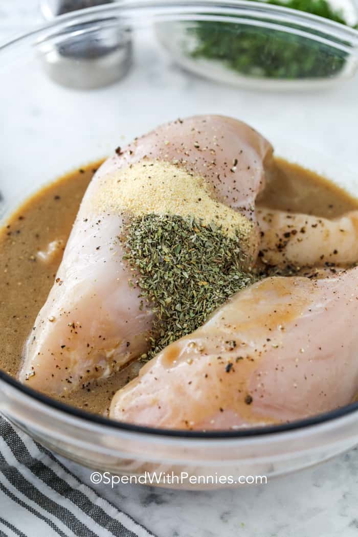 This chicken marinade makes tender and juicy chicken every time. It is so easy to make the best grilled chicken. The ingredients for this sauce have a hint of sweetness and a bright tangy flavor. Use it for chicken breasts, thighs, or wings. #chickenmarinade #grilledchickenmarinade #marinade #spendwithpennies Chicken Marinade and seasonings over chicken breasts