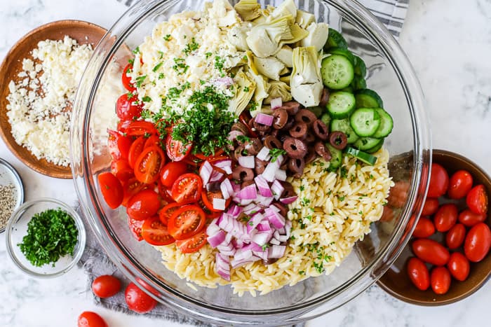 Mediterranean Orzo Salad ingredients with cucumbers and artichokes and tomatoes