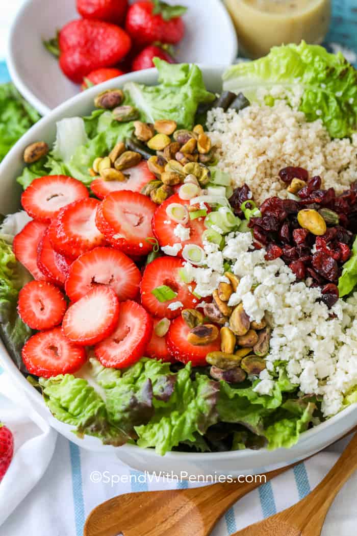 Make this easy and delicious strawberry salad for lunch or dinner, and enjoy it with extras or add-ins. It's fresh and colorful and loaded with healthy ingredients that taste great together. It's perfect for any occasion, and kids and grownups both will love it. Try it with chicken, salmon, or shrimp added in for a full meal deal. Healthy never tasted so good. #strawberrysalad #pistachiostrawberrysalad #salad #recipe #spendwithpennies Strawberry Pistachio Salad ingredients in a bowl