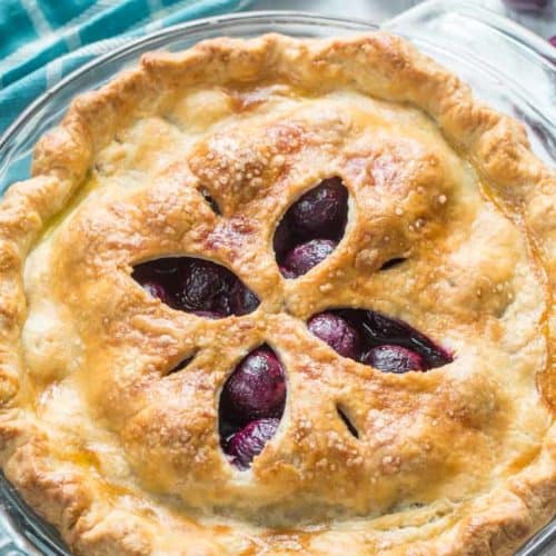 Whole uncut Cherry Pie in a glass pie dish