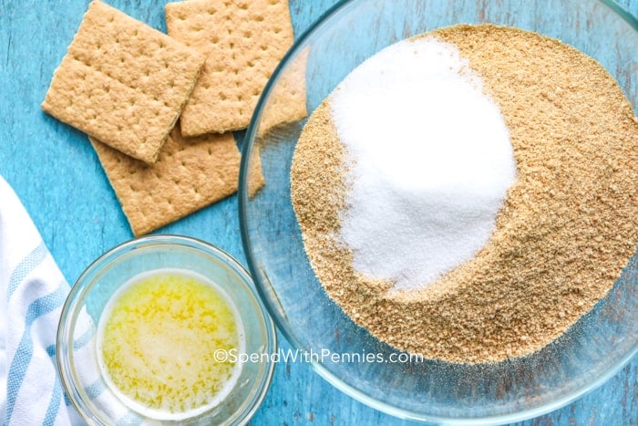 Overhead shot of Graham Cracker Crust ingredients in bowls with a few graham crackers on the side