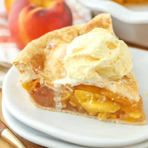 Slice of Homemade Peach Pie with ice cream on a plate