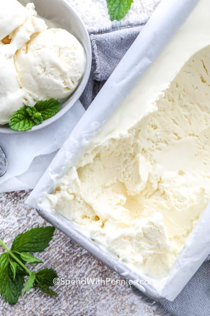 No Churn ice cream in a loaf pan with some scooped-out into a bowl