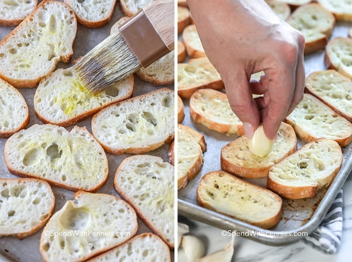 Pieces of bread being brushed with butter and being rubbed with garlic on a sheet pan