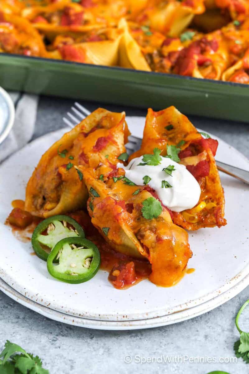 Pasta shells stuffed with ground beef and topped with cheese, sour cream, and cilantro