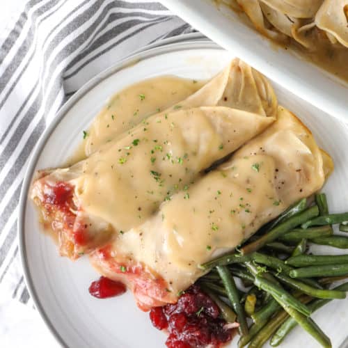 Turkey Roll-Ups on a plate with green beans and gravy
