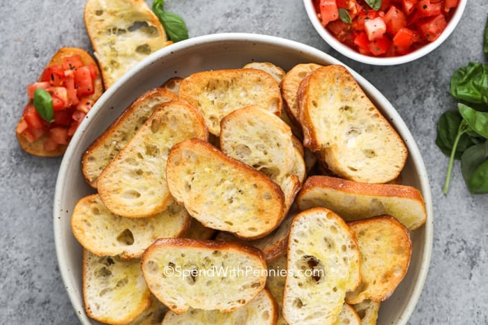 Crostini in a bowl with Bruschetta on the side