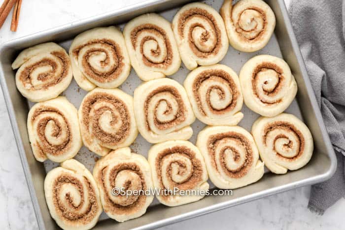 Whip up homemade cinnamon rolls with soft dough, cozy spices, and a creamy frosting. The cinnamon and brown sugar filling bakes into tender, gooey layers that melt in your mouth. Frost them warm for the perfect finish. Make ahead for busy mornings or treat your family and friends on special occasions. #spendwithpennies Raw cinnamon rolls in a pan