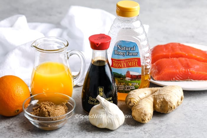 This orange-glazed salmon recipe is easy to prepare! Salmon fillets are marinated in a homemade ginger orange glaze and oven baked for the perfect flakey texture. #bakedsalmon #salmonmarinade #easyrecipe #spendwithpennies Ingredients for the marinade for Baked salmon filets