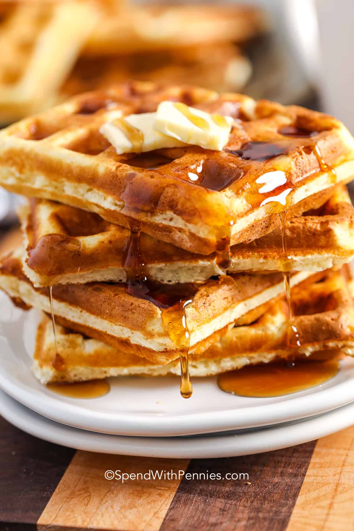 a plate of waffles with syrup and butter