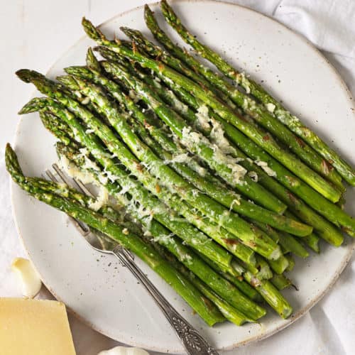 Parmesan roasted asparagus on a serving platter with parmesan and garlic.