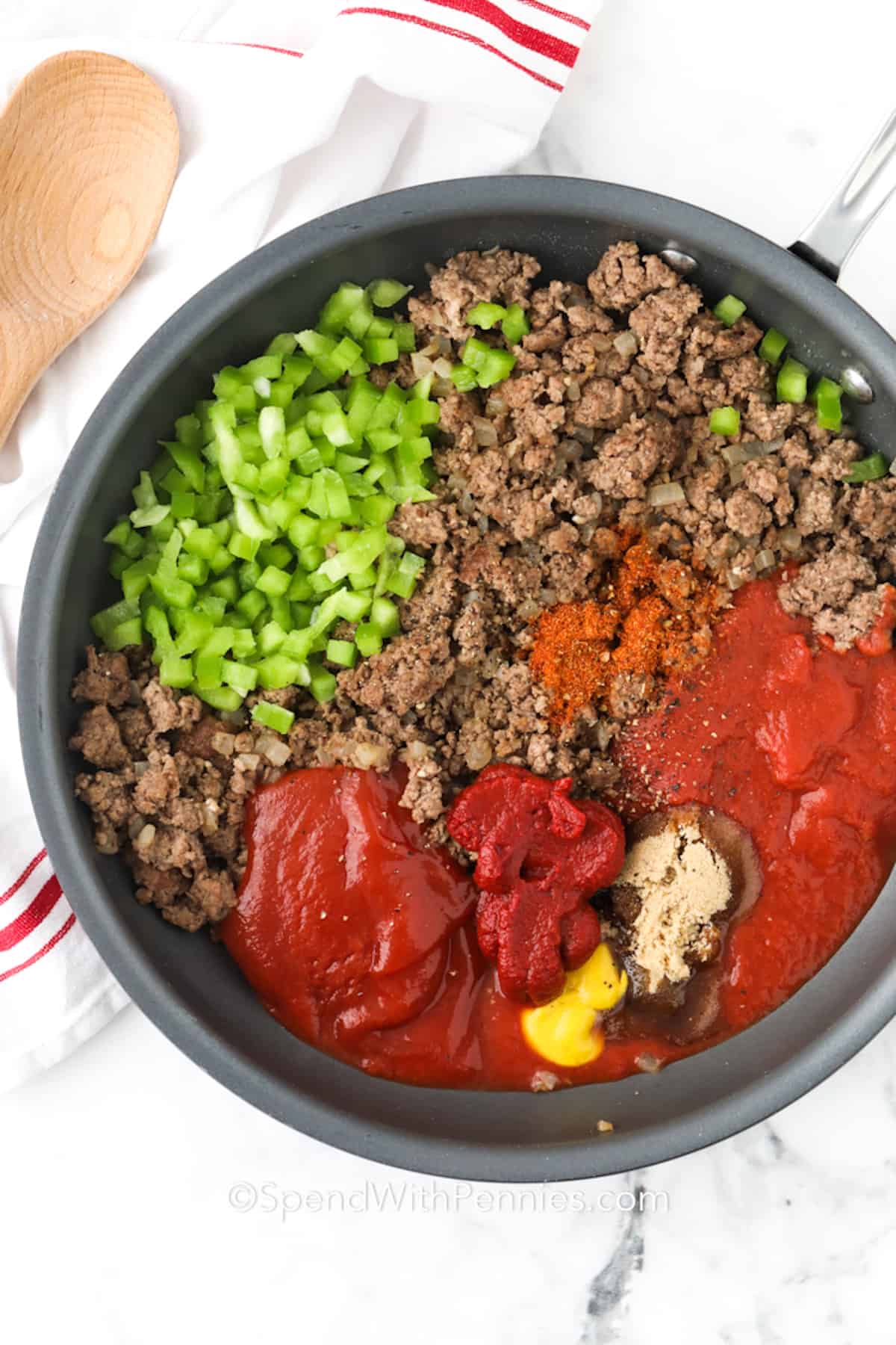 With this Sloppy Joe recipe, dinnertime is easier and tastier than ever! Lean ground beef, peppers, and a tangy, savory sauce make this meal a hit with everyone. Toasted buns bring an extra crunch to each bite! Perfect for a quick dinner or a party favorite; keep it warm in a Crockpot for guests. Make a big batch and freeze leftovers, so you’re always ready with a tasty meal! #spendwithpennies sloppy joe ingredients in a skillet