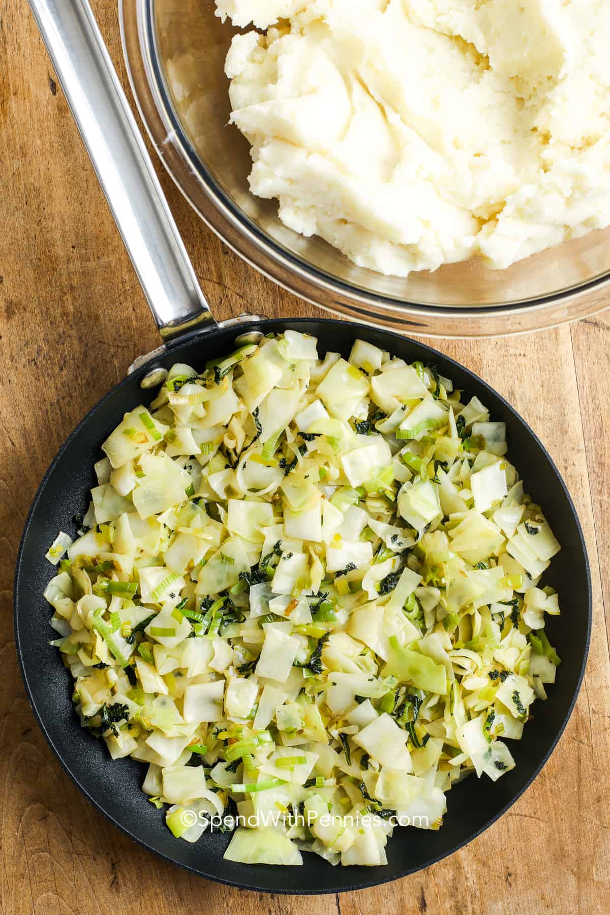 Colcannon is a traditional Irish dish consisting of cabbage and onion (or leeks) fried until tender and gently folded into rich and creamy mashed potatoes (I add a little bit of bacon too). This makes the most amazing side dish with ham or corned beef. #colcannon #mashedpotatoes #cabbage #cabbageandbacon #spendwithpennies frying cabbage and leeks for colcannon
