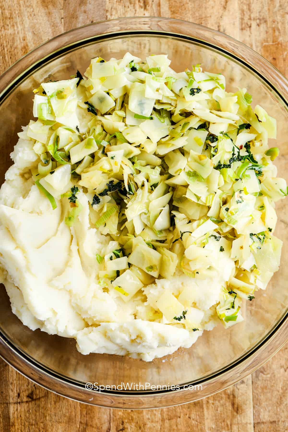 mixing mashed potatoes with cabbage and onions for colcannon