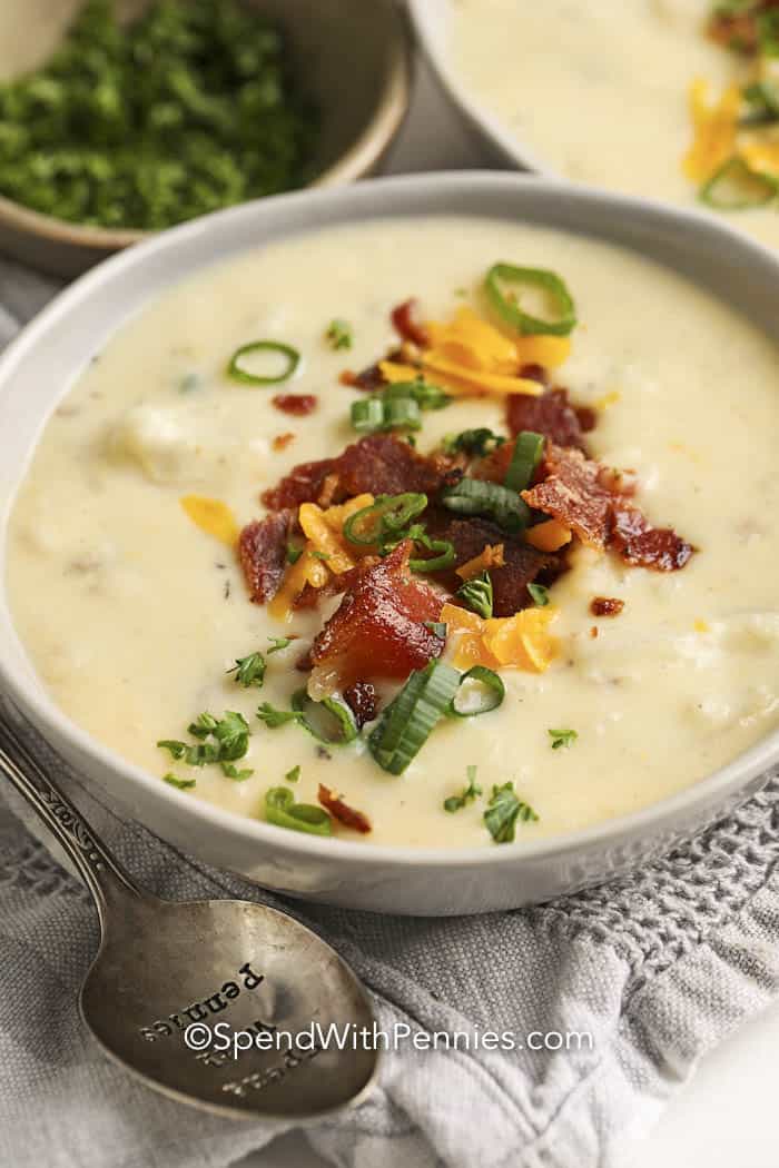 Bowl of Crockpot Potato Soup with green onion, bacon, cheese