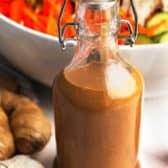 Peanut Dressing in a jar with salad behind