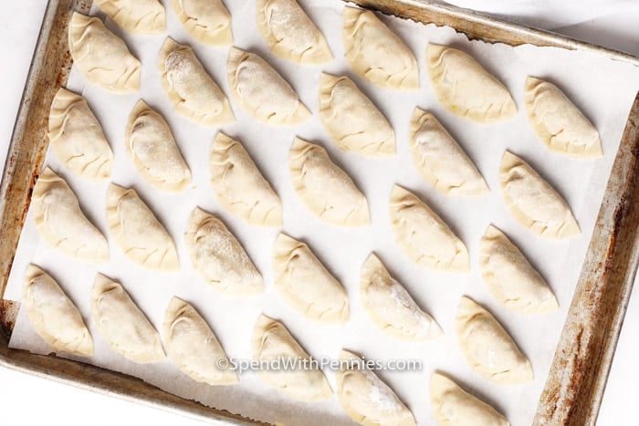 Immagine in alto di gnocchi di maiale crudi su una teglia.