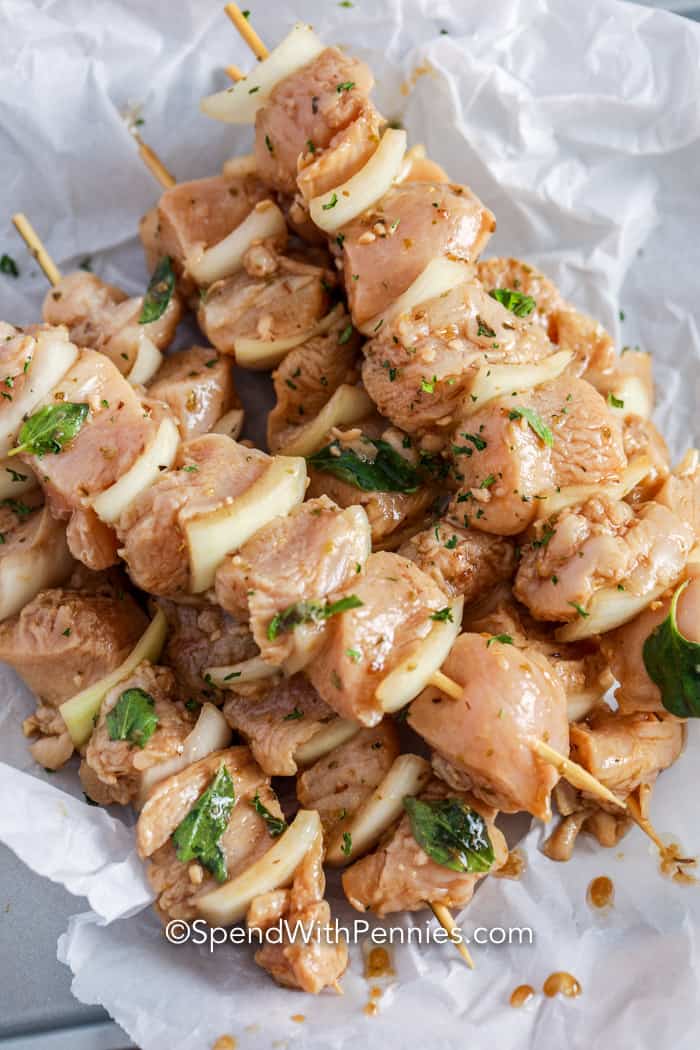 Chicken Souvlaki is a fast and easy meal that is perfect to prep ahead of time! Chicken and onions are tossed in a homemade marinade before being threaded onto a skewer and grilled. #spendwithpennies #souvlaki #chickensouvlaki #greek uncooked skewers of souvlaki