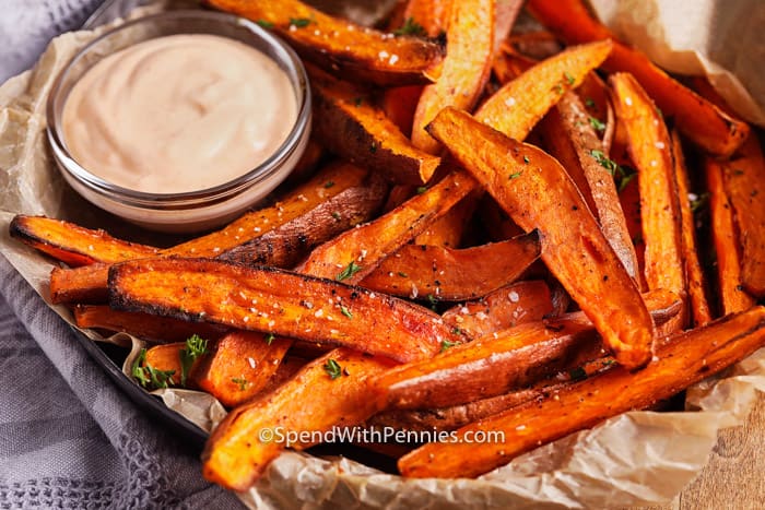 Oven-baked sweet potato fries are a crowd favorite! Only a handful of ingredients are needed to make these flavorful fries, just sweet potatoes, olive oil, and seasonings. Baked them until perfectly golden and watch them disappear! #sweetpotatofries #fries #yamfries #spendwithpennies Aioli and Sweet potato fries in a bowl