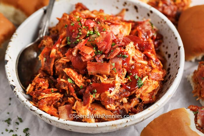 A serving dish of BBQ Chicken slider mixture, topped with bacon and parsley. 