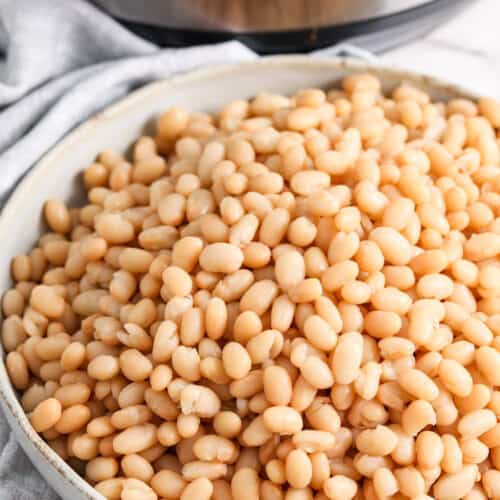 Instant Pot Beans in a white bowl with an instant pot behind it