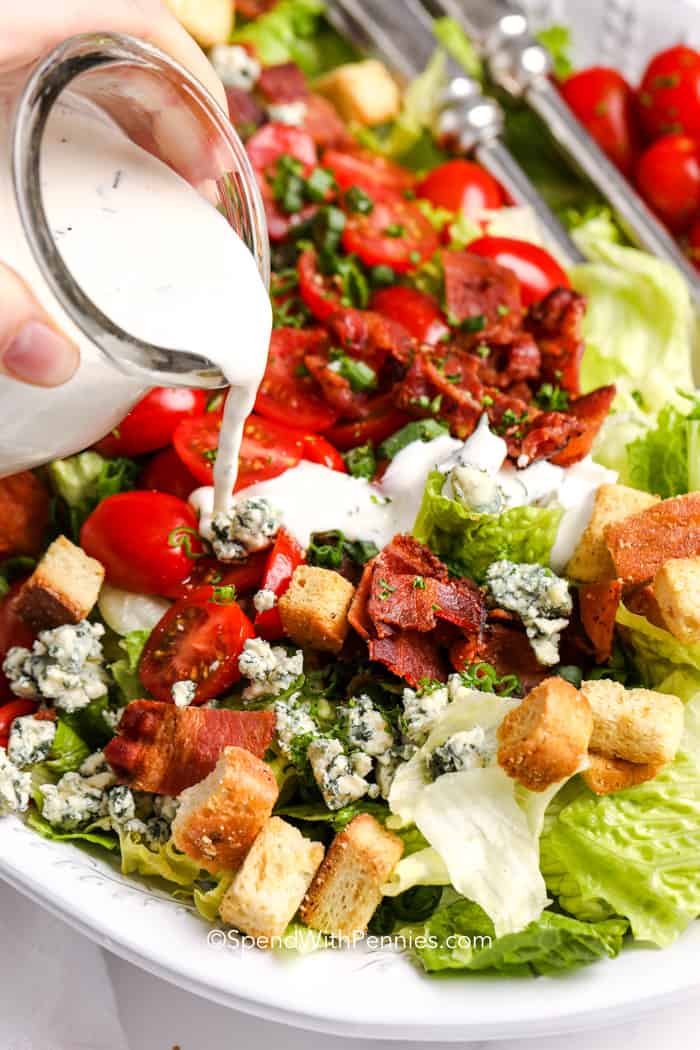 BLT Salad is a tasty combination of lettuce, tomato and bacon, just like the famous sandwich. You'll love the crunchiness of the lettuce, the juiciness of the tomatoes, and the delicious smoky flavor of the bacon, all mixed together. #bltsalad #blt #salad #recipe #spendwithpennies Pour a creamy herb dressing over a leafy salad