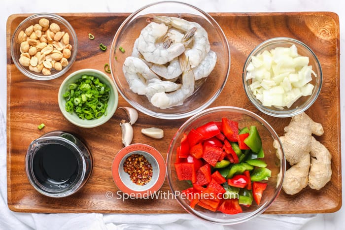 ingredients to make kung pao shrimp on a wooden board