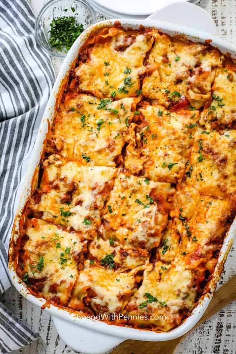We love serving this homemade lasagna with layers of sauce, cheese and noodles. Beef and sausage make the perfect meat sauce for this easy Italian meal! #spendwithpennies #lasagna #homemadelasagna #italianlasagna #easylasagna #classiclasagna pan of the best baked homemade lasagna on a white plate