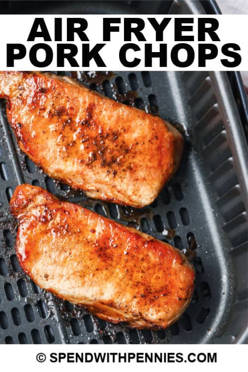 Two cooked pork chops in an air fryer with writing