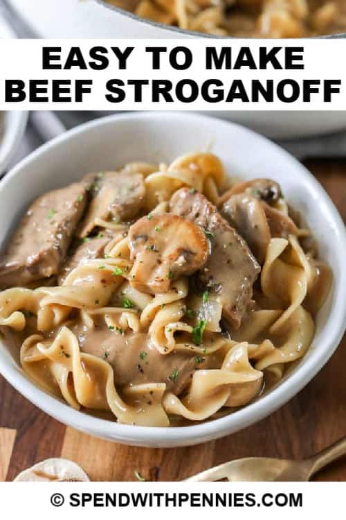Homemade beef stroganoff recipe is one of our favorite family dinners. It's full of tender juicy steak and earthy mushrooms in a rich, brown gravy sour cream sauce! #spendwithpennies #beef #stroganoff #beefstroganoff #easybeefstroganoff #beefmushroomstroganoff #beefstroganoffrecipe Easy Beef Stroganoff in a white bowl with writing