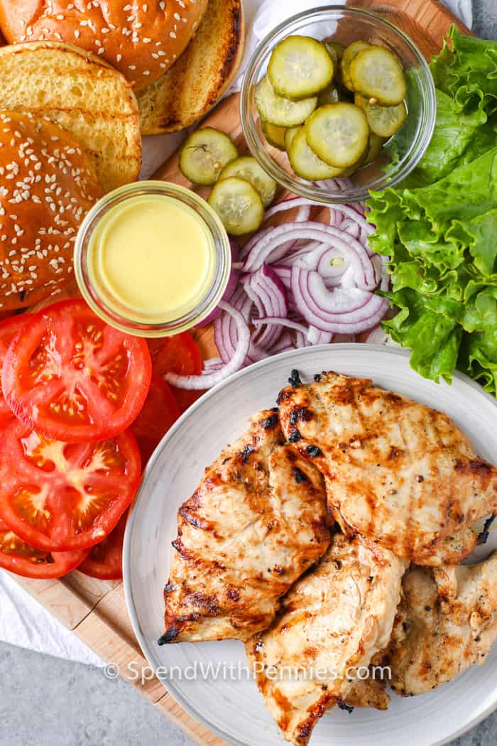 These grilled chicken sandwiches will be so hard to resist! Guests will be Impressed with this fun twist on a classic sandwich! The chicken is marinated in a zesty marinade and the cooked to tender and juicy perfection. It is just waiting for a soft bun, honey mustard, tomatoes, and lettuce. #grilledchickensandwich #grilledchickensandwichrecipe #easygrilledchickensandwich #spendwithpennies ingredients to make a Grilled Chicken Sandwich