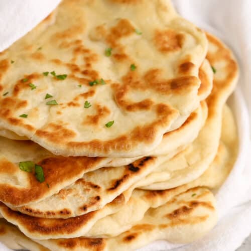 Prepared naan bread wrapped in a towel