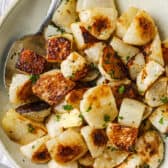 top view of Roasted Turnips on a white plate with a spoon