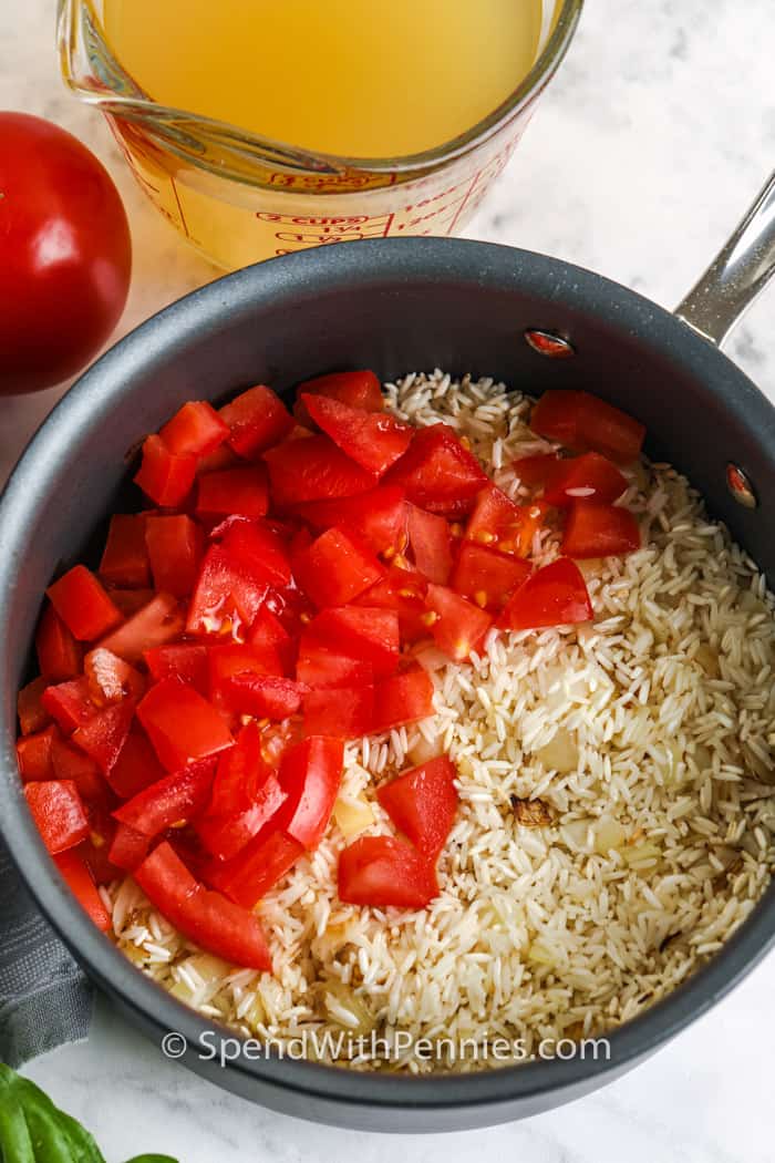 Tomato Basil Rice ingredients in a pot with broth on the side