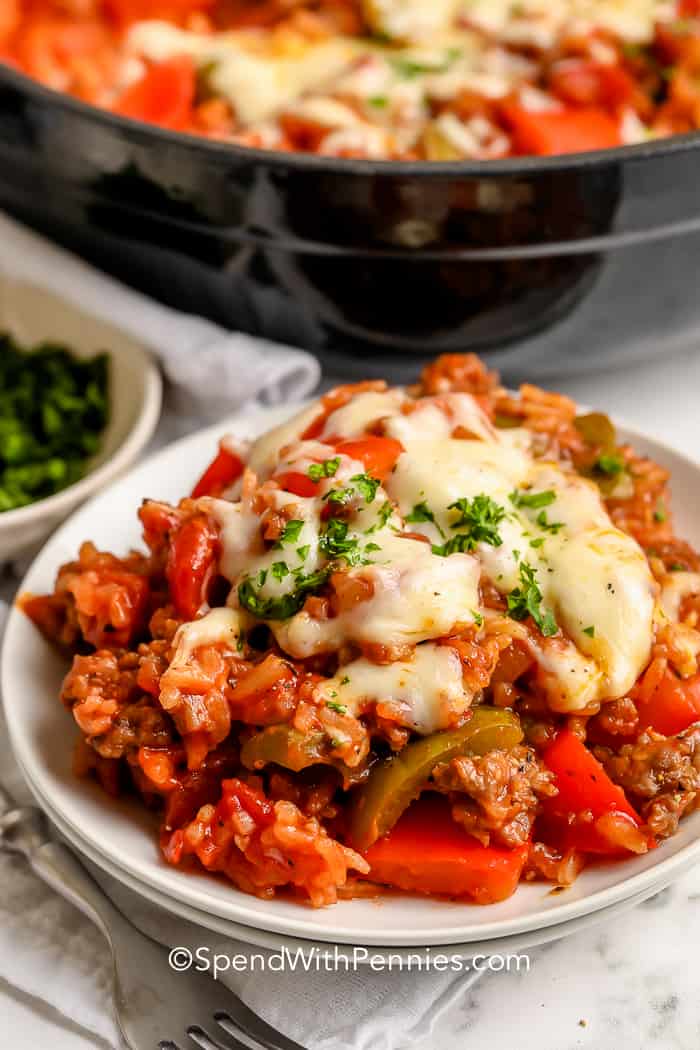 unstuffed peppers on a white plate topped with melted cheese and parsley