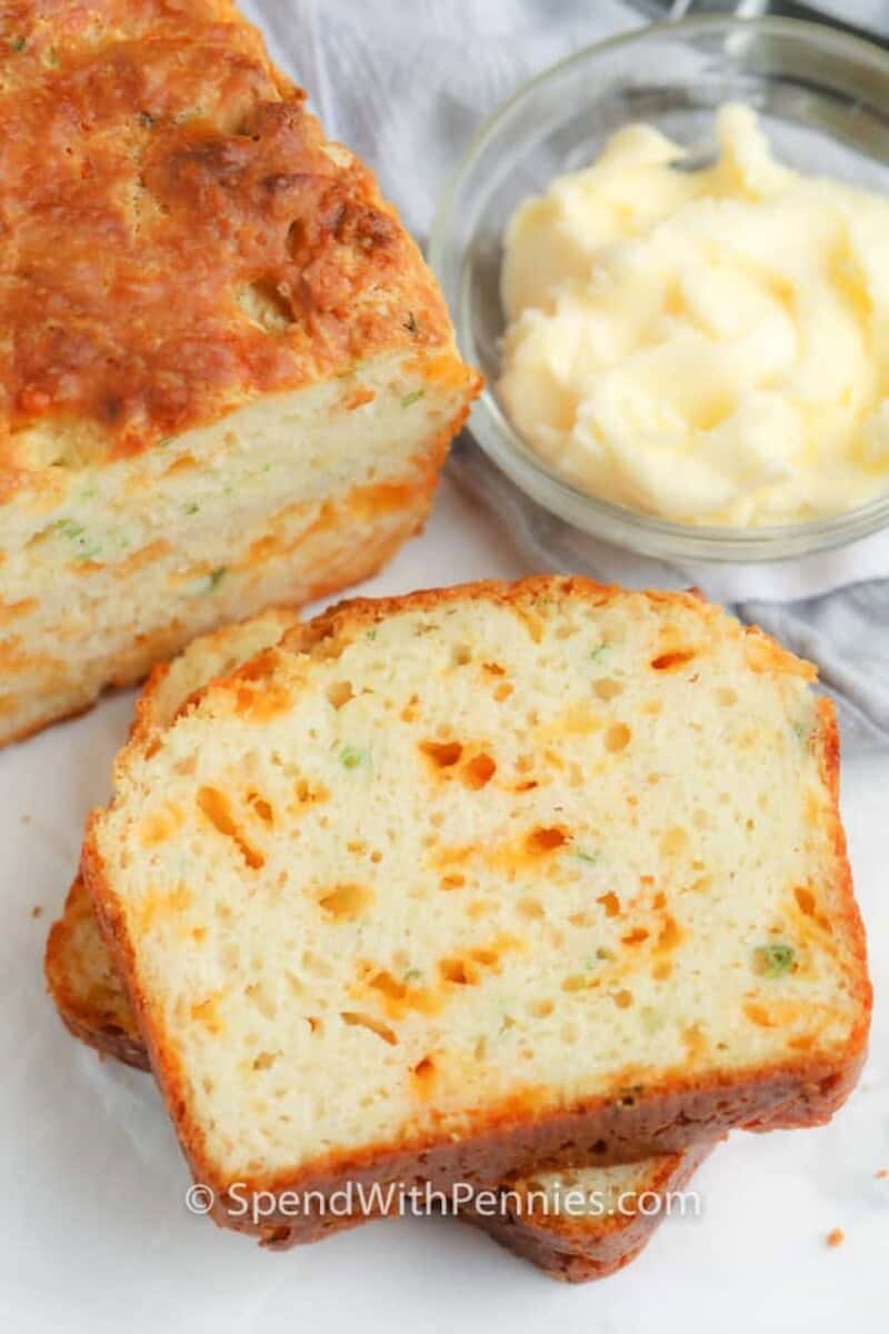a slice of cheese bread with butter in the background