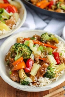 A bowl of pork stir fry over rice.