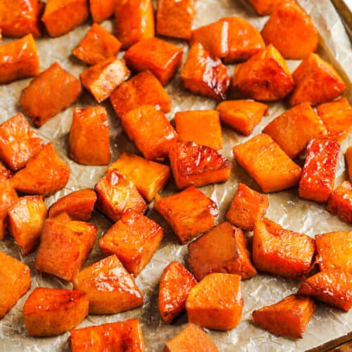 cooked Brown Sugar Roasted Sweet Potatoes on parchment paper and baking sheet