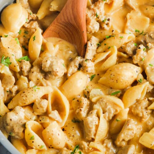 top view of Cheesy Ground Turkey Pasta cooking in a pot with a spoon
