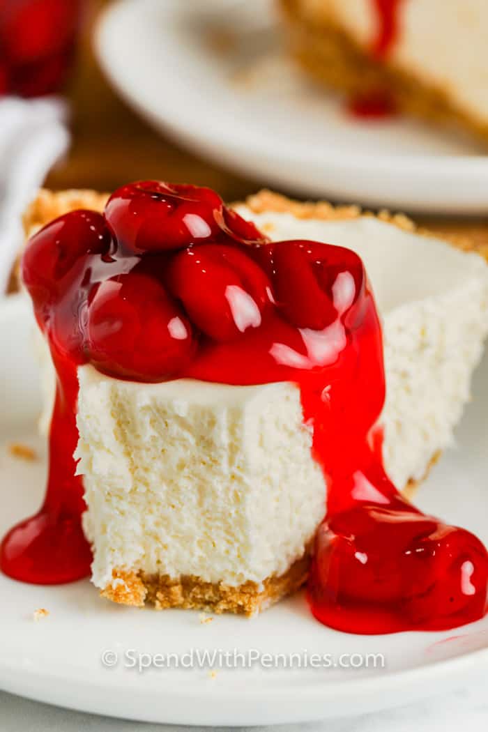 Make this no bake cheesecake recipe for dessert if you’re going to a potluck or dinner party! No baking required, just a handful of simple ingredients and chill until set. Then top it with cherry pie filling, caramel, or even chocolate sauce! #spendwithpennies close up of a slice of No Bake Cheesecake with a bite out of it