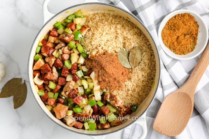 adding spices and rice to Cajun Jambalaya